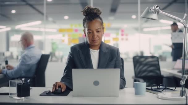 Афроамериканская женщина-менеджер работает за компьютером в офисе — стоковое видео