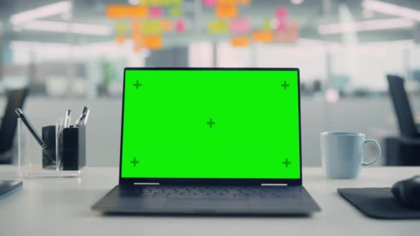 Laptopcomputer met groen scherm in leeg kantoor — Stockvideo