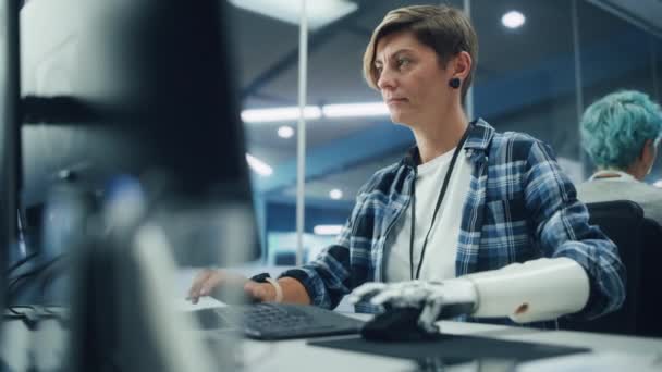 Женщина с протезной рукой работает на компьютере в офисе — стоковое видео