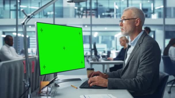 Geschäftsmann im Büro arbeitet am Green Screen Computer — Stockvideo