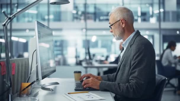 Hombre trabajando en la computadora en la oficina — Vídeos de Stock