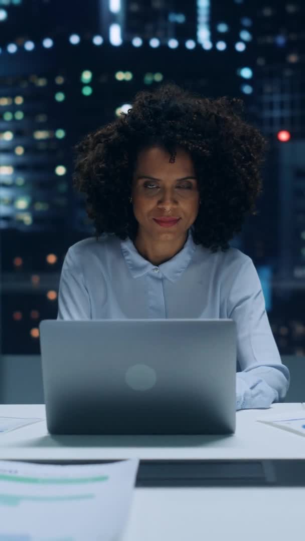 Gerente de negocios de pantalla vertical que trabaja en el ordenador portátil por la noche — Vídeos de Stock