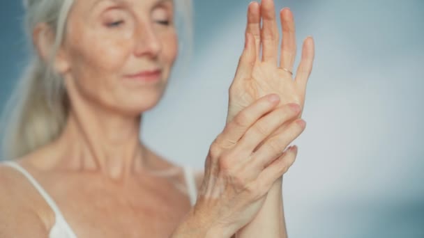 Ηλικιωμένη γυναίκα με κρέμα χεριών — Αρχείο Βίντεο