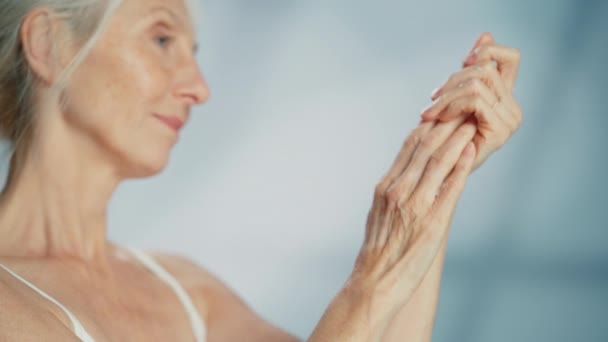 Старша жінка використовує крем для рук — стокове відео