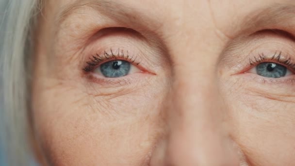 Ηλικιωμένη γυναίκα ομορφιά χρησιμοποιεί κρέμα ματιών — Αρχείο Βίντεο
