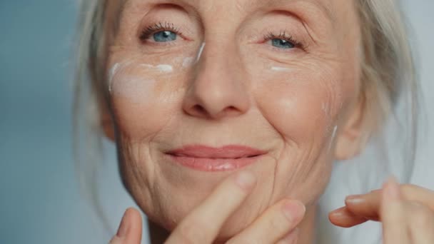 Mujer mayor belleza utiliza crema para los ojos — Vídeos de Stock