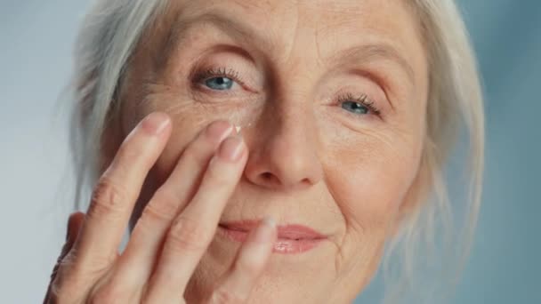 Senior mulher beleza usa creme facial — Vídeo de Stock
