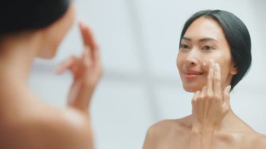 Aynada Yüz Kremi Kullanan Kadın