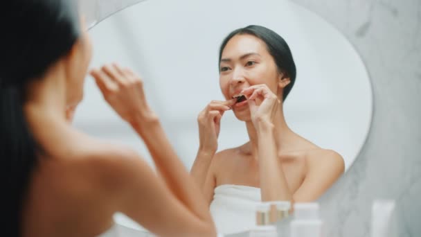 Jovem mulher adulta usa rosto creme espelho — Vídeo de Stock