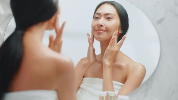 Mulher usando creme facial no espelho — Vídeo de Stock