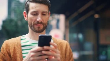 Sokakta akıllı telefon kullanan adam.