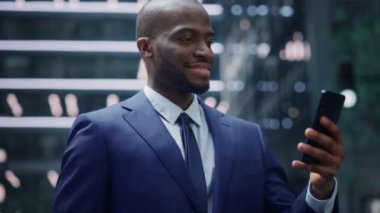 İş adamı sokakta akıllı telefon kullanıyor.