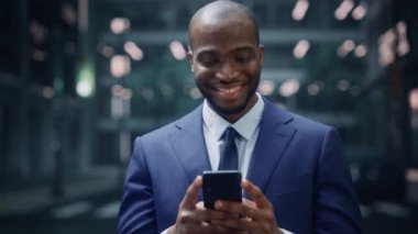 İş adamı sokakta akıllı telefon kullanıyor.