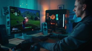Young Man Playing 3D Shooter on PC at Home
