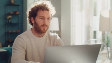 Evde dizüstü bilgisayar kullanan bir adam