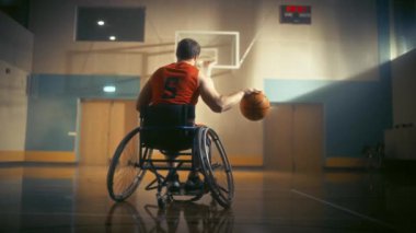 Tekerlekli sandalyedeki basketbol oyuncusu top sürüyor.