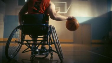 Tekerlekli sandalyedeki basketbol oyuncusu top sürüyor.