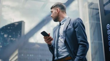İşadamı Asansöre Binerken Akıllı Telefon Kullanıyor