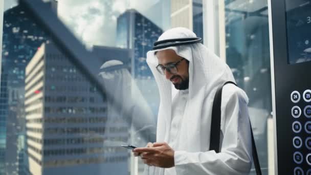 Άραβας επιχειρηματίας Riding Ανελκυστήρας χρησιμοποιώντας Smartphone — Αρχείο Βίντεο