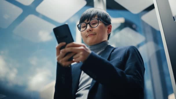 Ιαπωνικά Businessman Riding ασανσέρ χρησιμοποιώντας Smartphone — Αρχείο Βίντεο