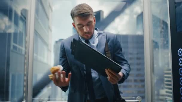 Бизнесмен спешит есть бургер в лифте — стоковое видео
