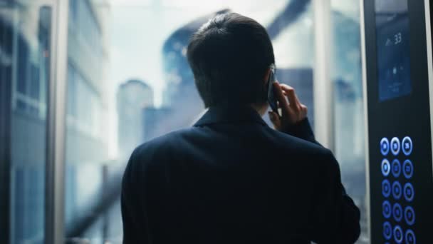 Japanese Businessman Riding Elevator Talking on Smartphone — стокове відео