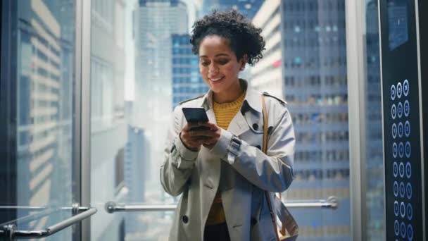 Latina feminino equitação elevador para o escritório usando Smartphone — Vídeo de Stock