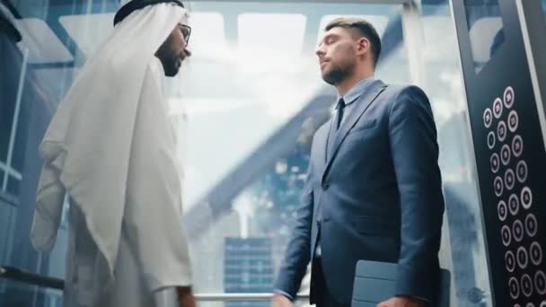 Два международных бизнесмена в лифте — стоковое видео