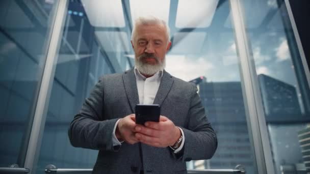 Hombre de negocios de la Edad Media que monta el elevador usando Smartphone — Vídeo de stock