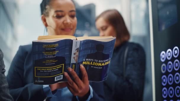 Μαύρη γυναικεία ιππασία Ανελκυστήρας ανάγνωση βιβλίο — Αρχείο Βίντεο