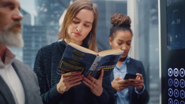 Elevador femenino lectura libro — Vídeos de Stock