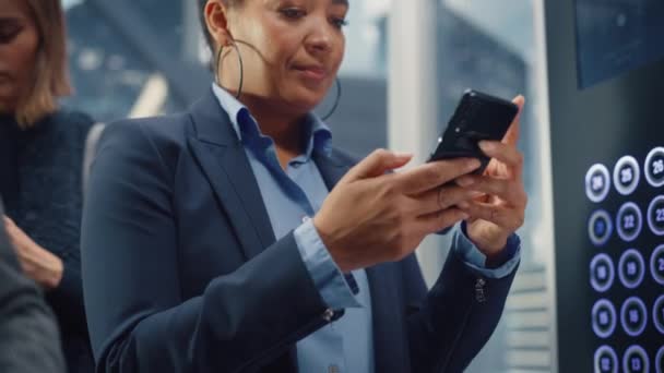 Elevador femenino negro a la oficina usando Smartphone — Vídeo de stock