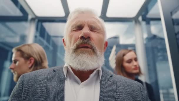 Mann mittleren Alters niest in überfülltem Fahrstuhl — Stockvideo