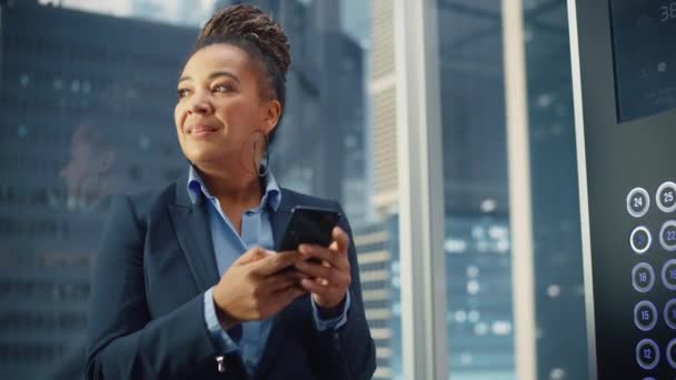 Elevador femenino negro a la oficina usando Smartphone — Vídeos de Stock