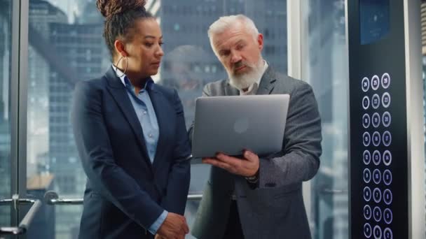 Женщины и мужчины-предприниматели в лифте с помощью ноутбука — стоковое видео