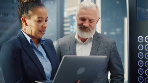 Vrouwelijke en mannelijke ondernemers in de lift met behulp van laptop — Stockvideo