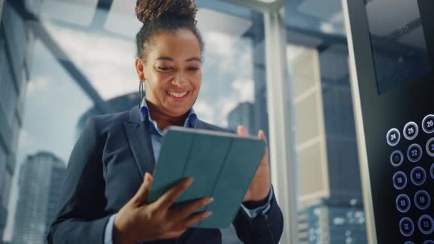 Elevador femenino negro a la oficina usando la tableta — Vídeos de Stock