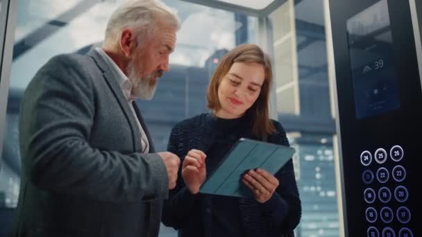 Businesspeople femenino y masculino en elevador usando la tableta — Vídeos de Stock