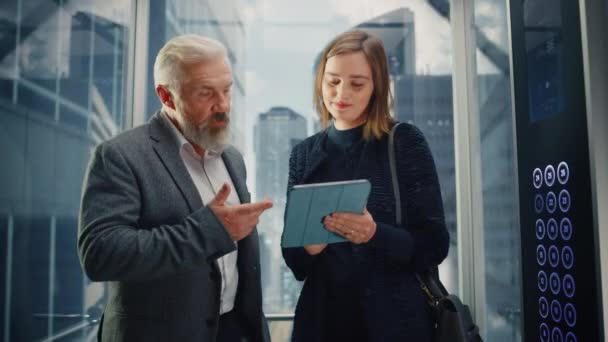 Γυναίκα και Άνδρας Επιχειρηματίες στο Ασανσέρ Χρησιμοποιώντας Tablet — Αρχείο Βίντεο