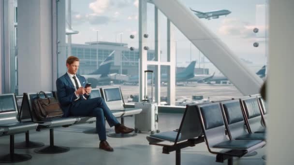 Geschäftsmann nutzt Smartphone-Wartezeit am Flughafen-Terminal — Stockvideo