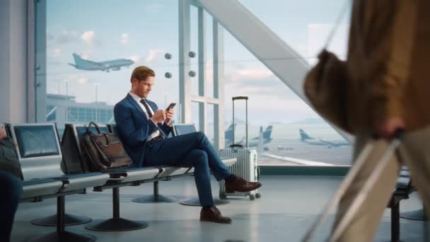 Empresário usa Smartphone Esperando no Terminal do Aeroporto — Vídeo de Stock