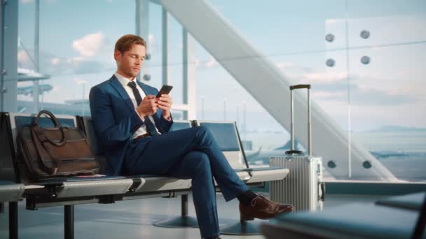 Podnikatel používá Smartphone čekání na letištním terminálu — Stock video