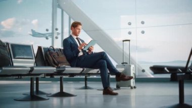 İşadamı, Havalimanı Terminalinde Bekleyen Tablet Bilgisayar kullanıyor
