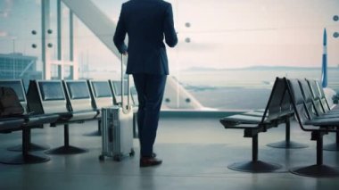 İşadamı, Havalimanı Terminalinde Bekleyen Tablet Bilgisayar kullanıyor