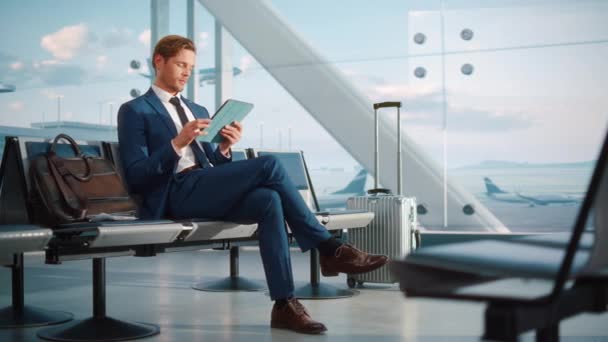 Homme d'affaires utilise Tablet Computer en attente au terminal de l'aéroport — Video