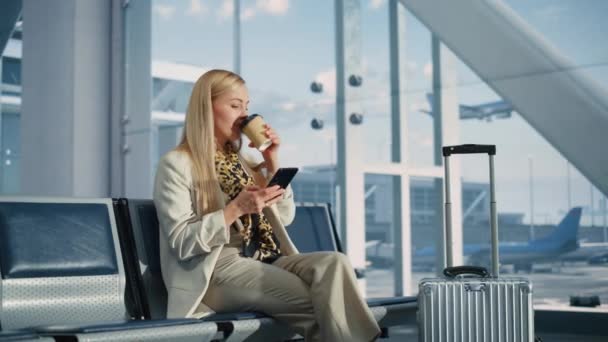 Kvinde ved hjælp af Smartphone Venter på flyvning i lufthavnen Terminal – Stock-video