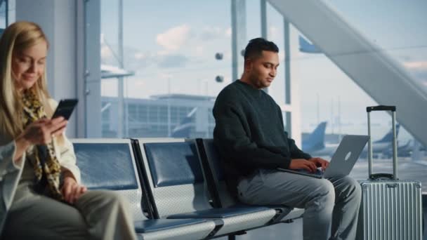 Жінка користується смартфоном Чекаючи на політ в терміналі аеропорту — стокове відео