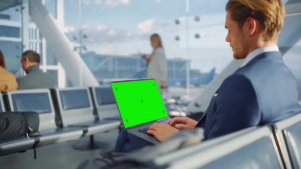 Empresario que usa el ordenador portátil de pantalla verde en el aeropuerto — Vídeos de Stock