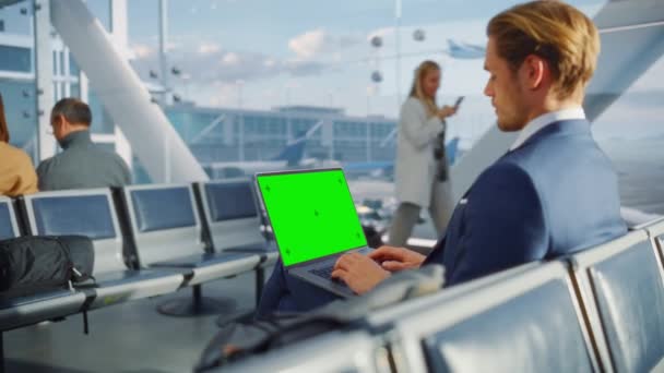空港のグリーンスクリーンラップトップを使用しているビジネスマン — ストック動画