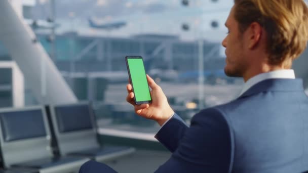 Επιχειρηματίας Χρησιμοποιώντας Πράσινη οθόνη Smartphone στο αεροδρόμιο — Αρχείο Βίντεο